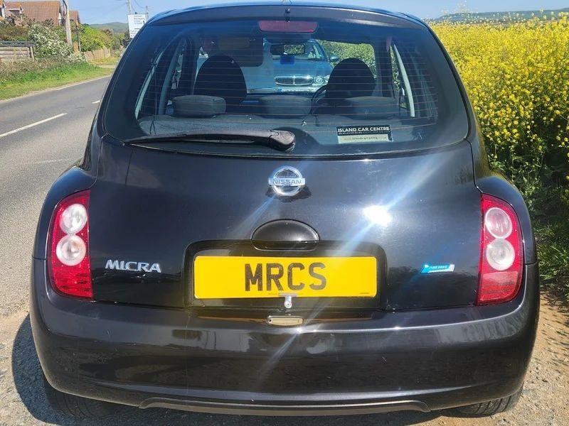 A black Nissan Micra viewed from the back