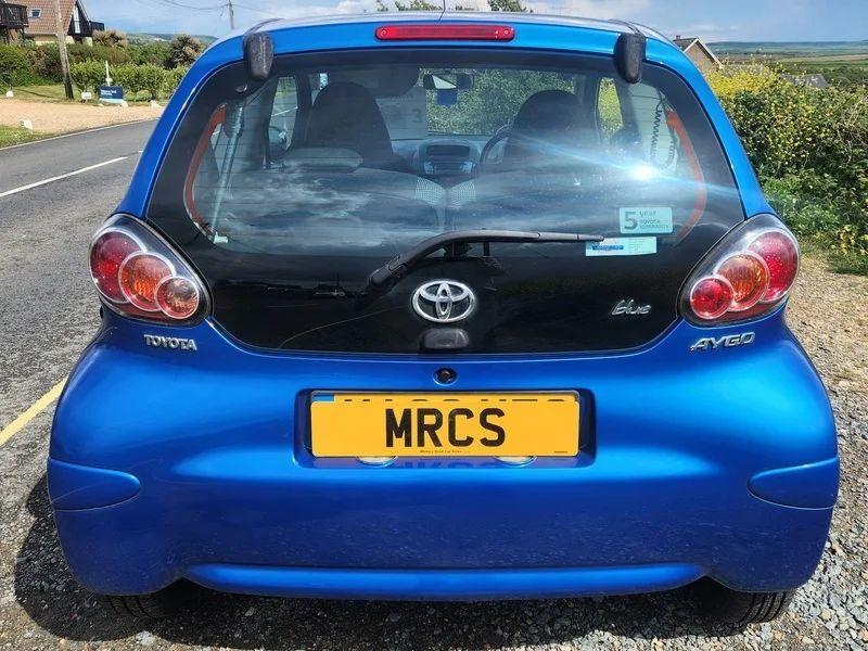 A blue Toyota Aygo viewed from the back