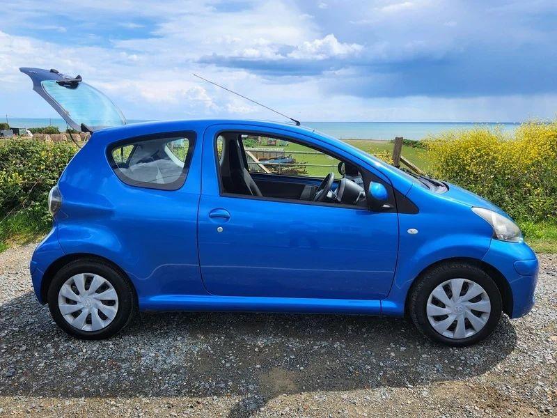A blue Toyota Aygo viewed from the driver side