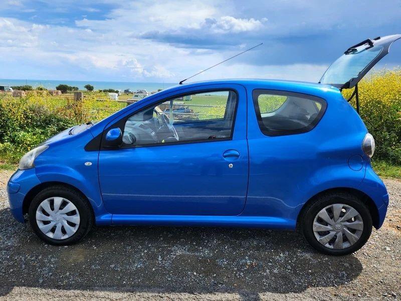 A blue Toyota Aygo viewed from the passenger side