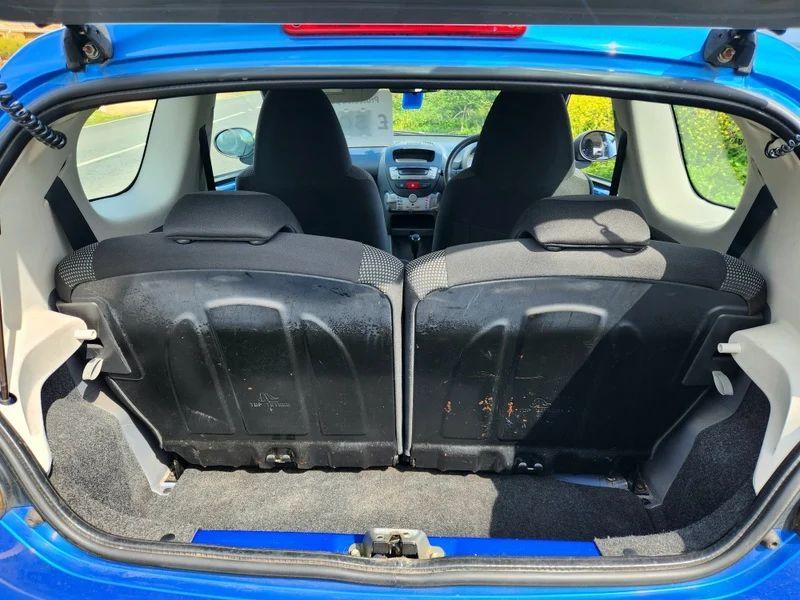 The open boot of a blue Toyota Aygo viewed from the back