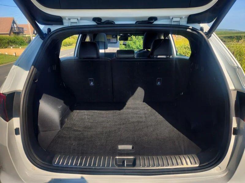 The open boot of a white KIA Sportage viewed from the back