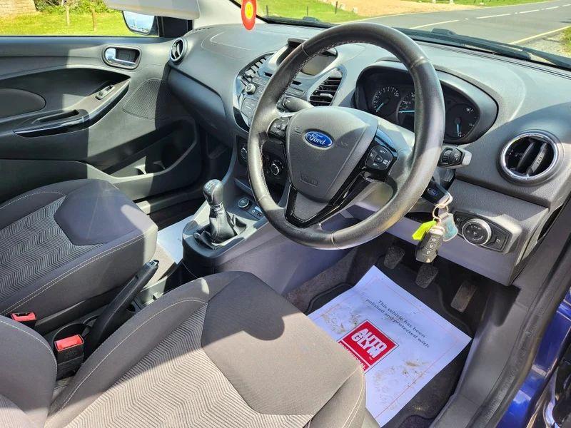 The steering controls of a blue Ford Ka viewed from above the driver seat