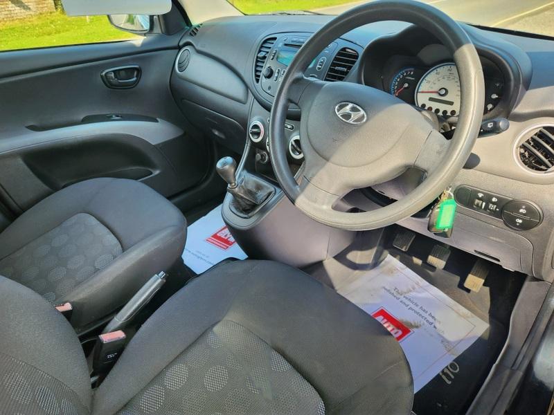 The steering controls of a black Hyundai i10 viewed from above the driver seat