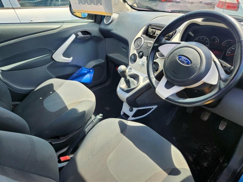 The steering controls of a blue Ford Ka viewed from above the driver seat