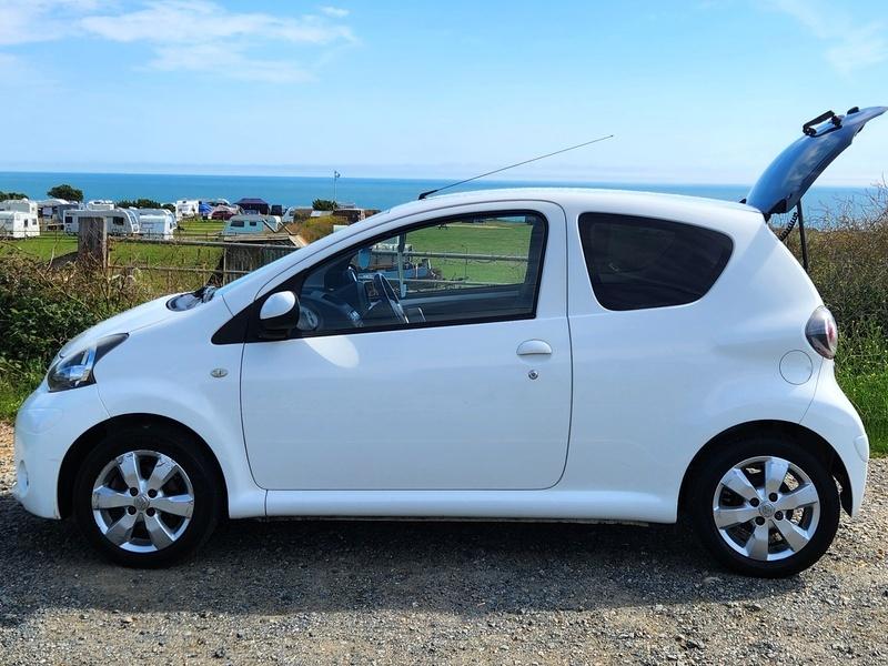 A white Toyota Aygo viewed from the passenger side