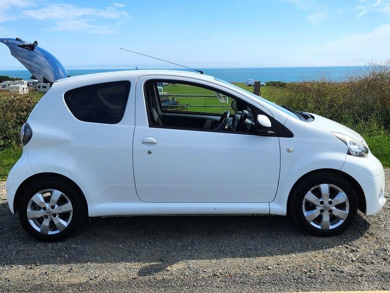 A white Toyota Aygo viewed from the driver side