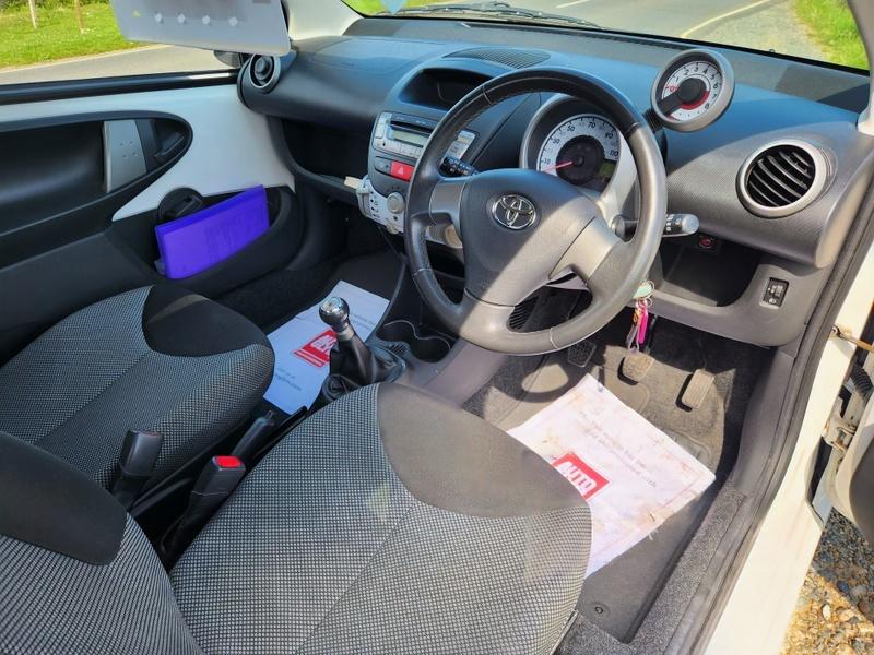 The steering controls of a white Toyota Aygo viewed from above the driver seat