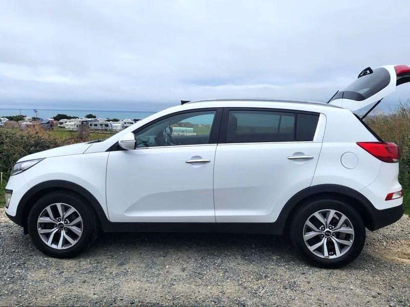 A white Kia Sportage viewed from the passenger side