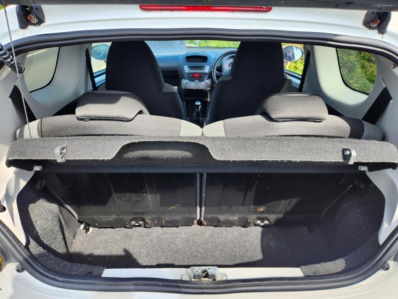 The open boot of a white Toyota Aygo viewed from the back
