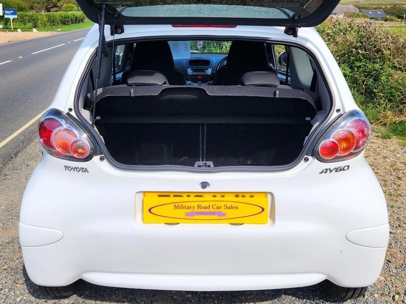 The open boot of a white Toyota Aygo viewed from the back