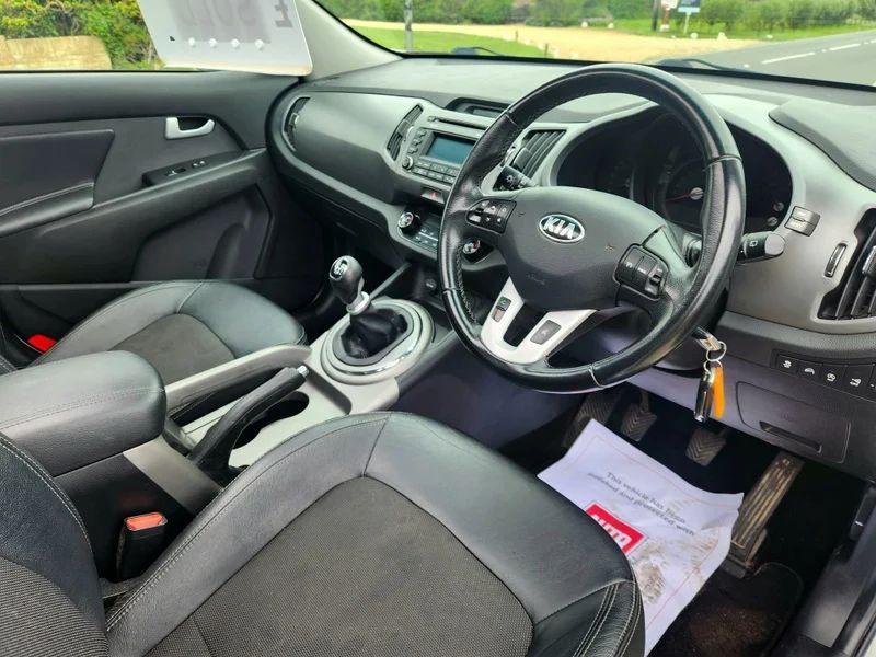 The steering controls of a white Kia Sportage viewed from above the driver seat