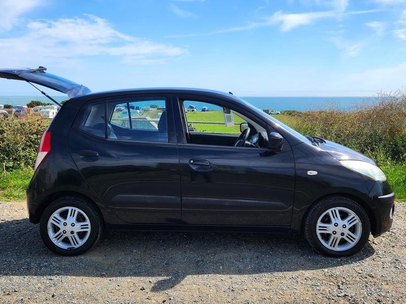 A black Hyundai i10 viewed from the driver side