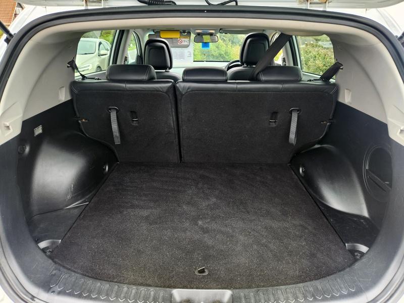The open boot of a white Kia Sportage viewed from the back
