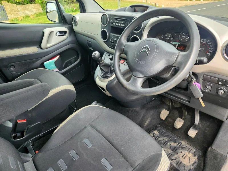 The steering controls of a black Citroen Berlingo viewed from above the driver seat