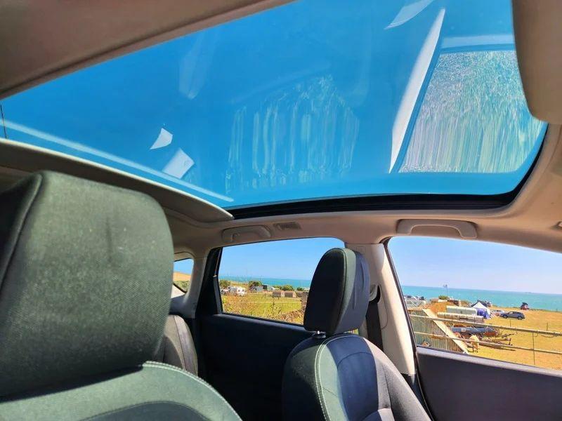 The sunroof of a gold Nissan Qashqai viewed from the driver seat