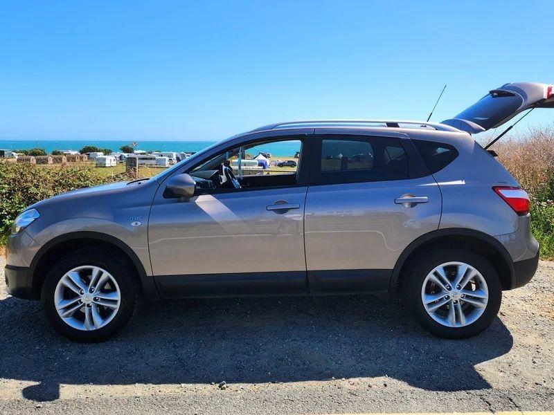 A gold Nissan Qashqai viewed from the passenger side