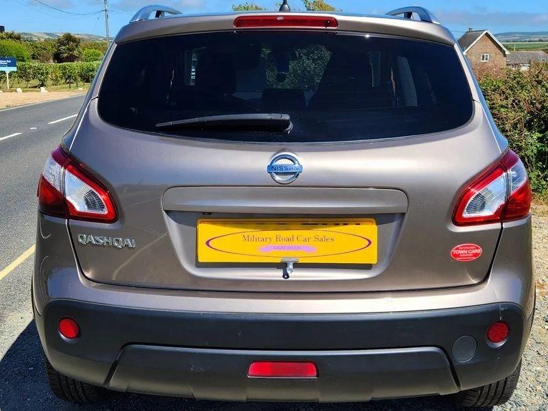 A gold Nissan Qashqai viewed from the back