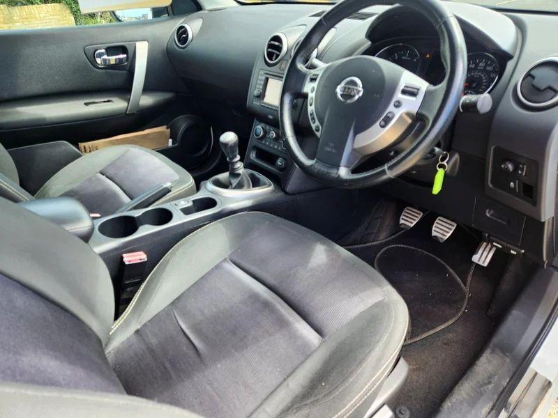 The steering controls of a white Nissan Qashqai viewed from above the driver seat