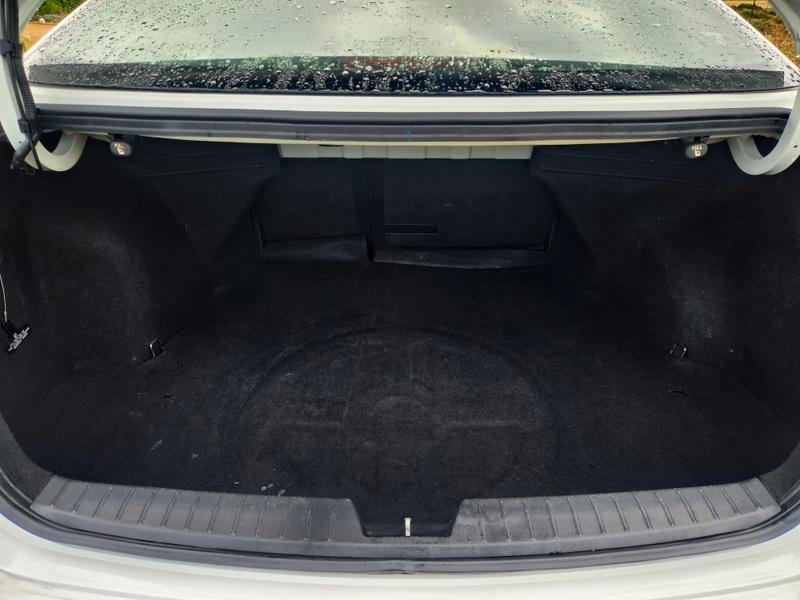 The open boot of a white Kia Optima viewed from the back