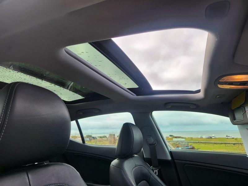The open sunroof of a white Kia Optima