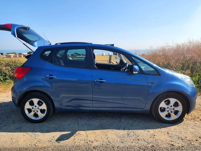 A blue Kia Venga viewed from the driver side