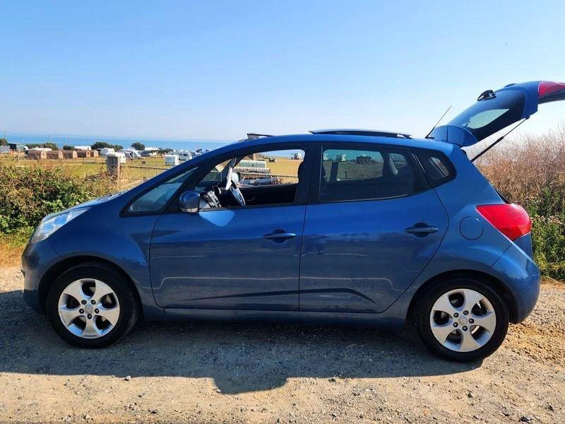 A blue Kia Venga viewed from the passenger side