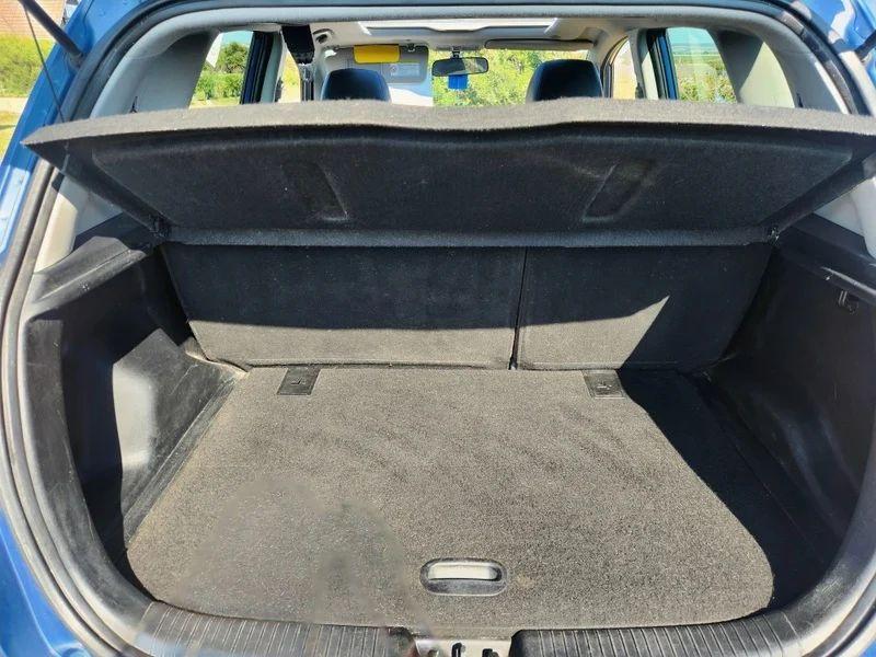 The open boot of a blue Kia Venga viewed from the back