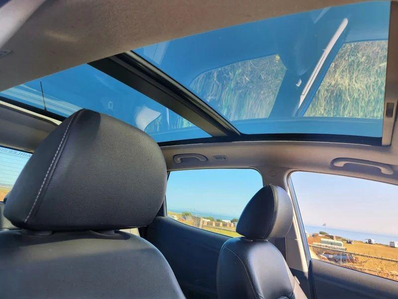 The sunroof of a blue Kia Venga viewed from the driver seat