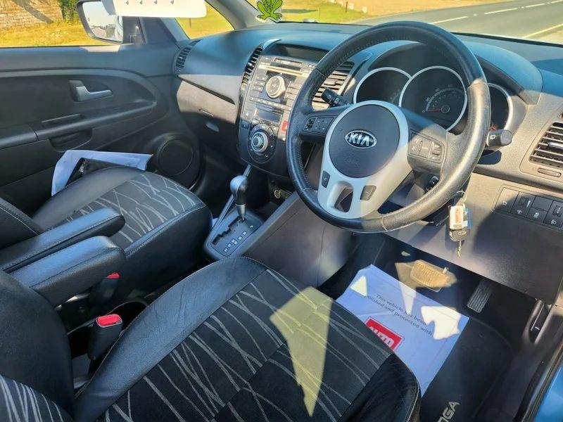The steering controls of a blue Kia Venga viewed from above the driver seat