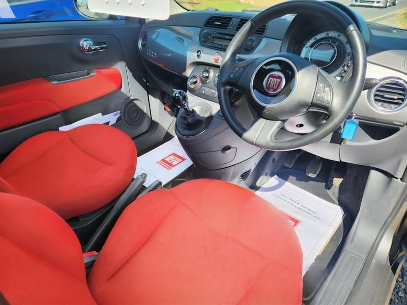 The steering controls of a grey Fiat 500 viewed from above the driver seat