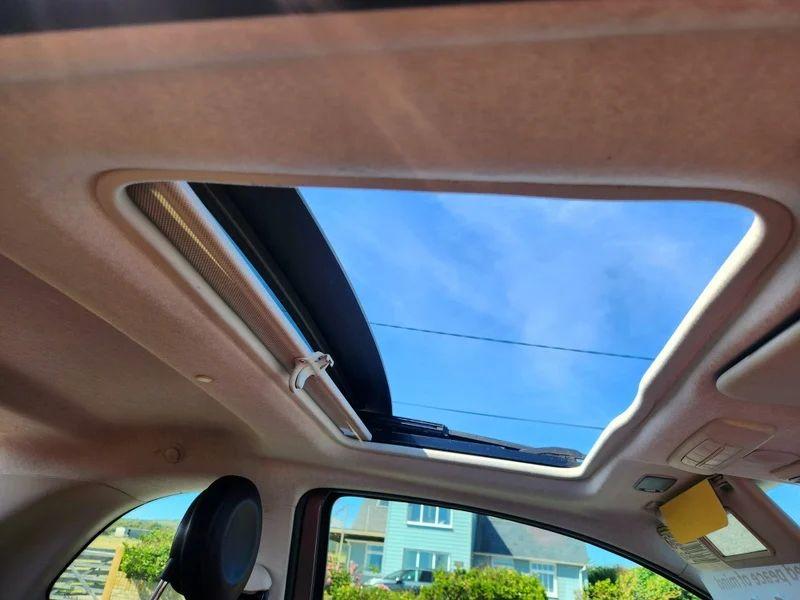 The sunroof of a grey Fiat 500 viewed from the driver seat