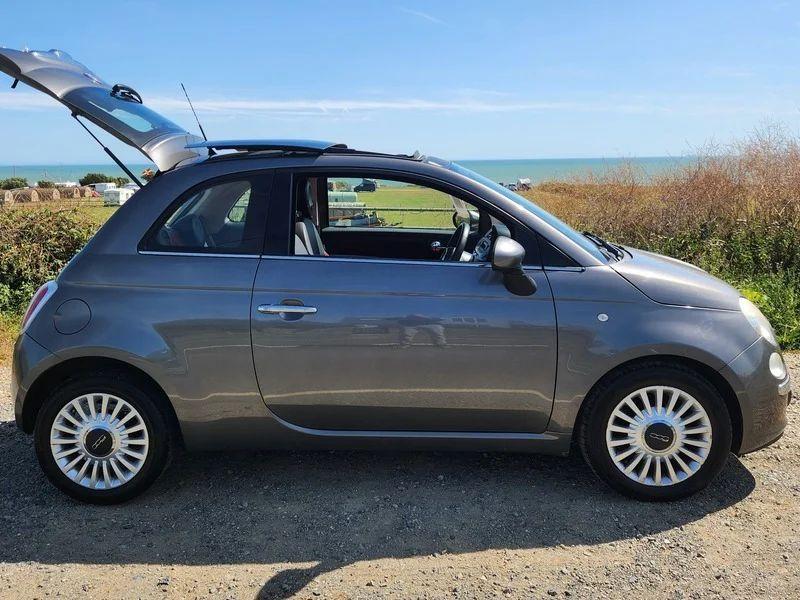 A grey Fiat 500 viewed from the driver side.