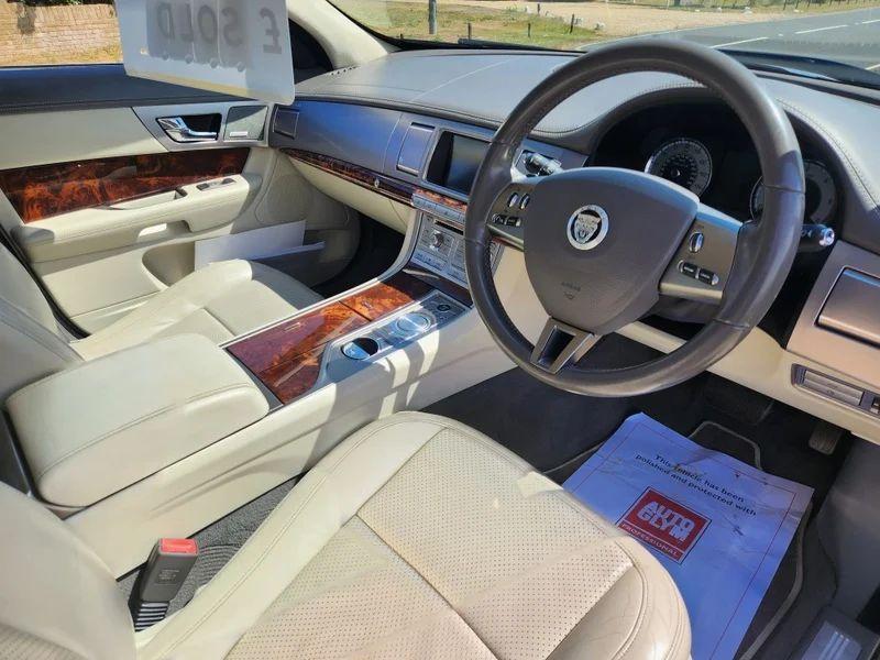 The steering controls of a grey Jaguar XF viewed from above the driver seat