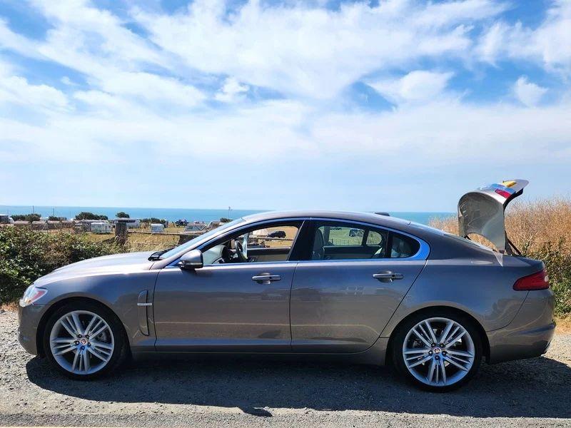 A grey Jaguar XF viewed from the passenger side