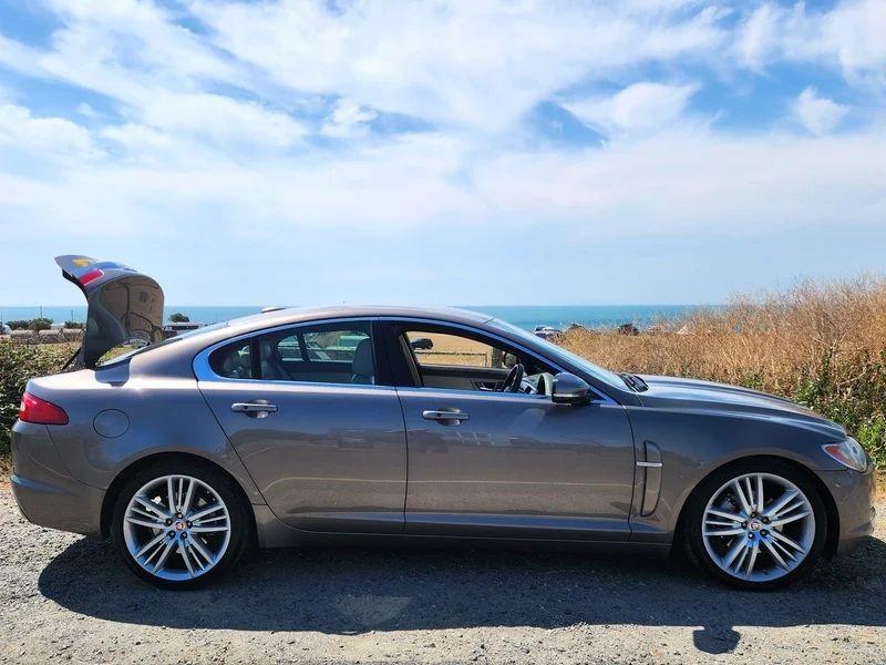 A grey Jaguar XF viewed from the driver side