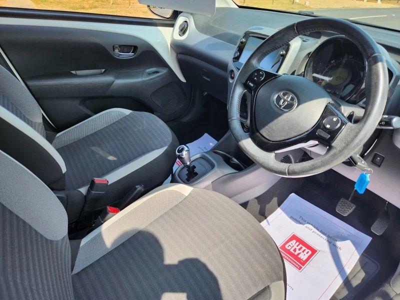 The steering controls of a white Toyota Aygo viewed from above the driver seat
