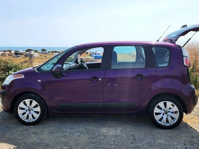 A violet Citroen C3 Picasso viewed from the passenger side