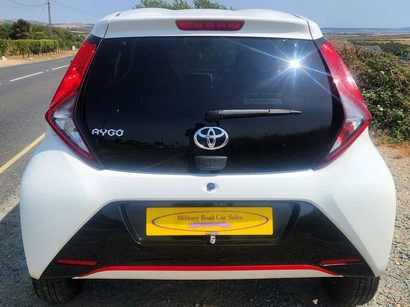 A white Toyota Aygo viewed from the back