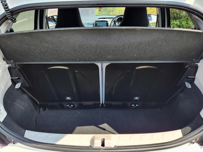 The open boot of a white Toyota Aygo viewed from the back