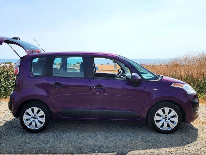 A violet Citroen C3 Picasso viewed from the driver side
