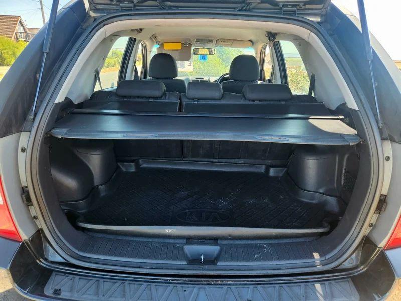 The open boot of a black Kia Sportage viewed from the back