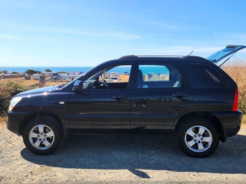 A black Kia Sportage viewed from the passenger side