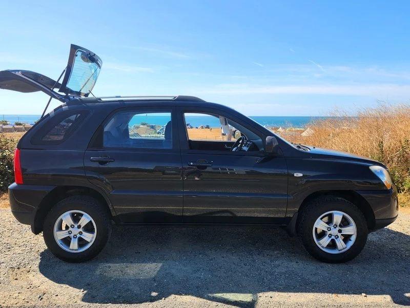 A black Kia Sportage viewed from the driver side