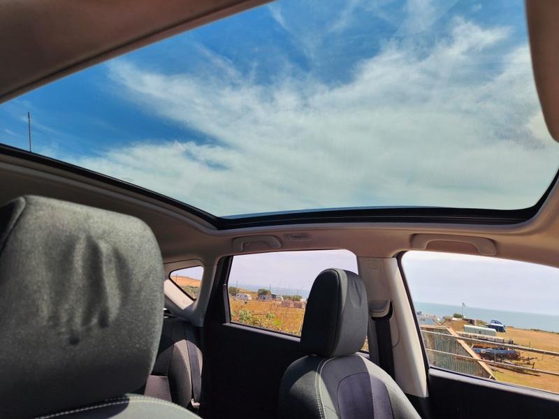 The sunroof of a black Nissan Qashqai viewed up from the driver seat