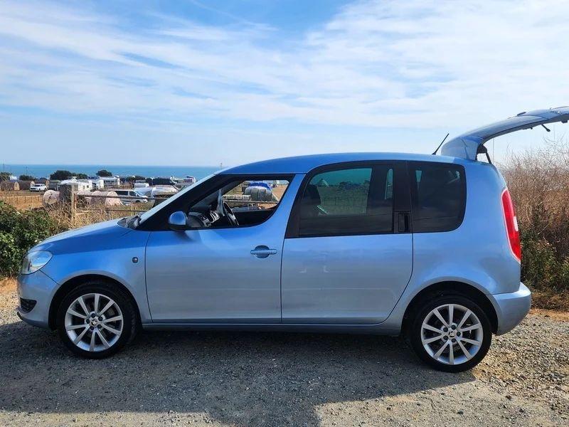 A silver blue Skoda Roomster viewed from the passenger side