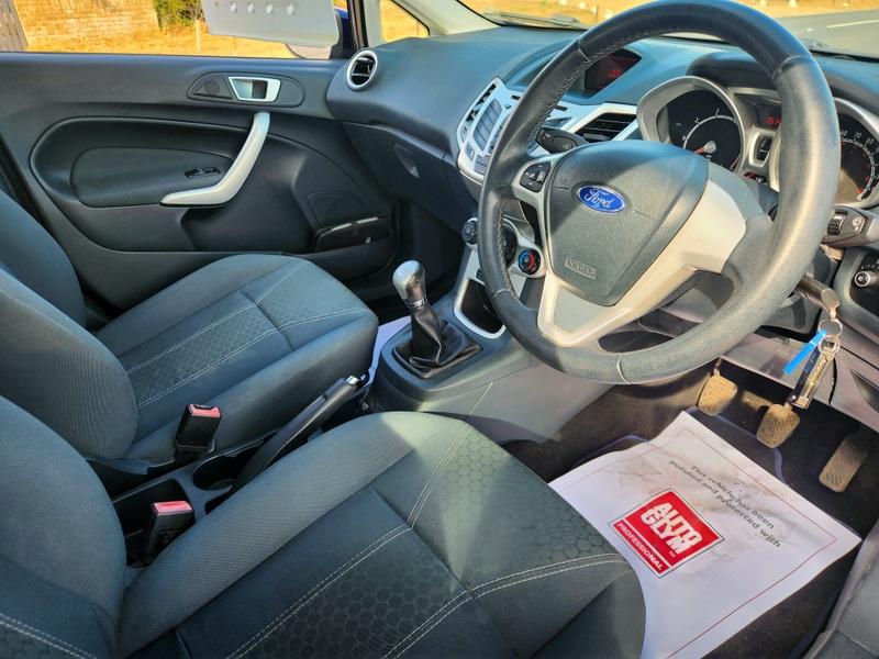 The steering controls of a Deep Midnight Blue Ford Fiesta viewed from above the driver seat