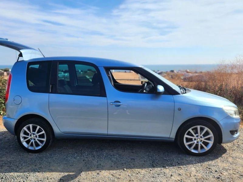 A silver blue Skoda Roomster viewed from the driver side