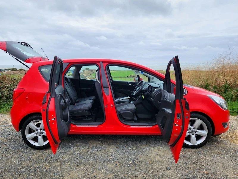 A Magma Red Solid Vauxhall Meriva with doors open viewed from the driver side