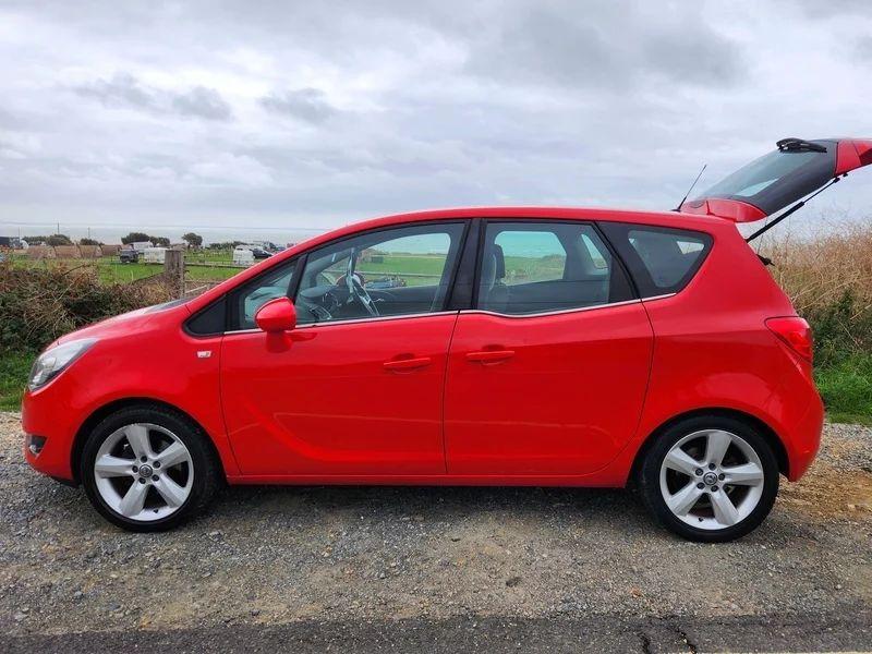 A Magma Red Solid Vauxhall Meriva viewed from the passenger side